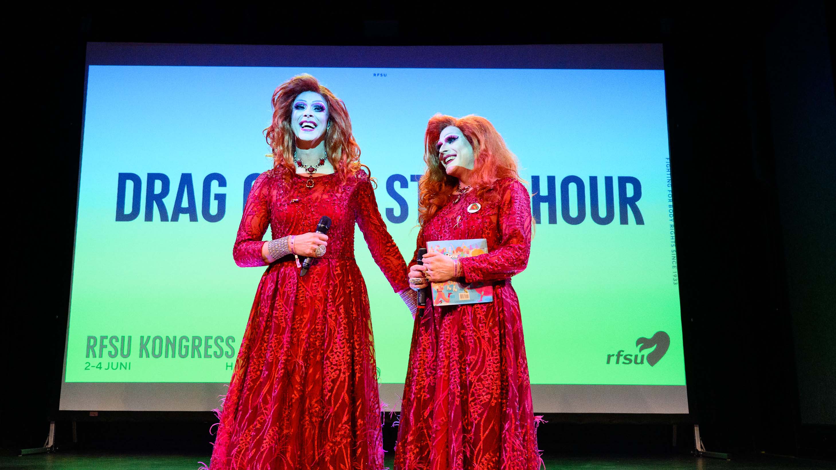 Lady Busty och Miss Shameless från Drag Queen Story Hour står på scenen under RFSU:s kongress 2023, leende, foto. 