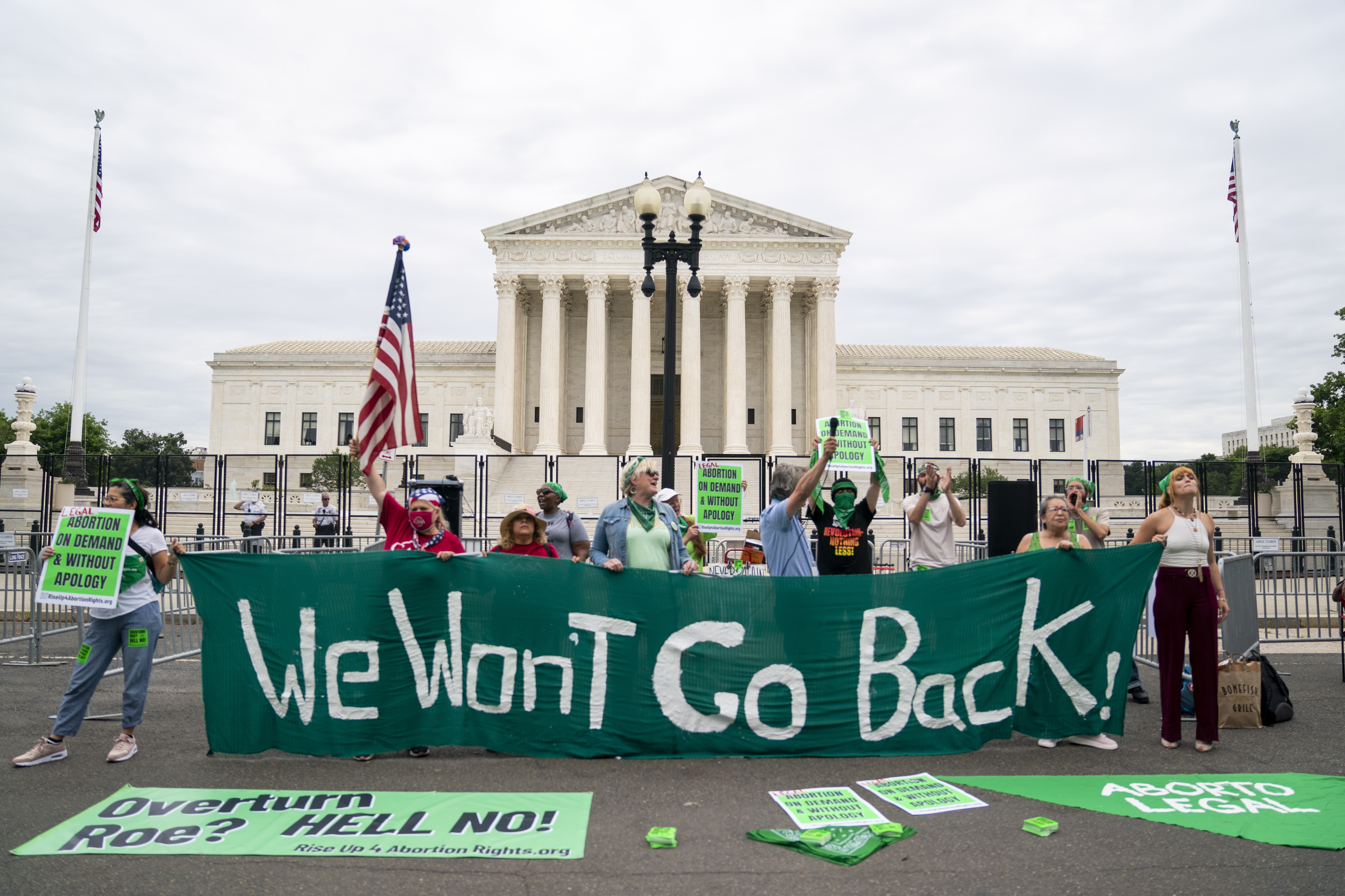 Aborträttsdemonstration utanför Högsta domstolen i USA. Aktivister håller upp en banderoll med texten: "We won't go back".  