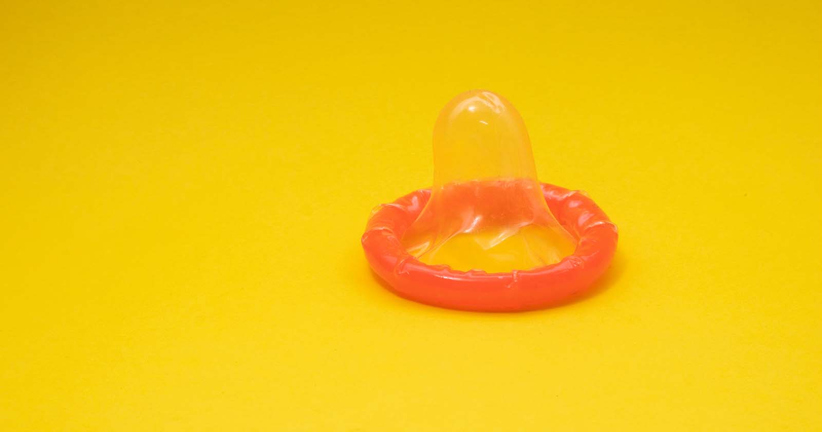 Orangeröd kondom på en gul bakgrund 