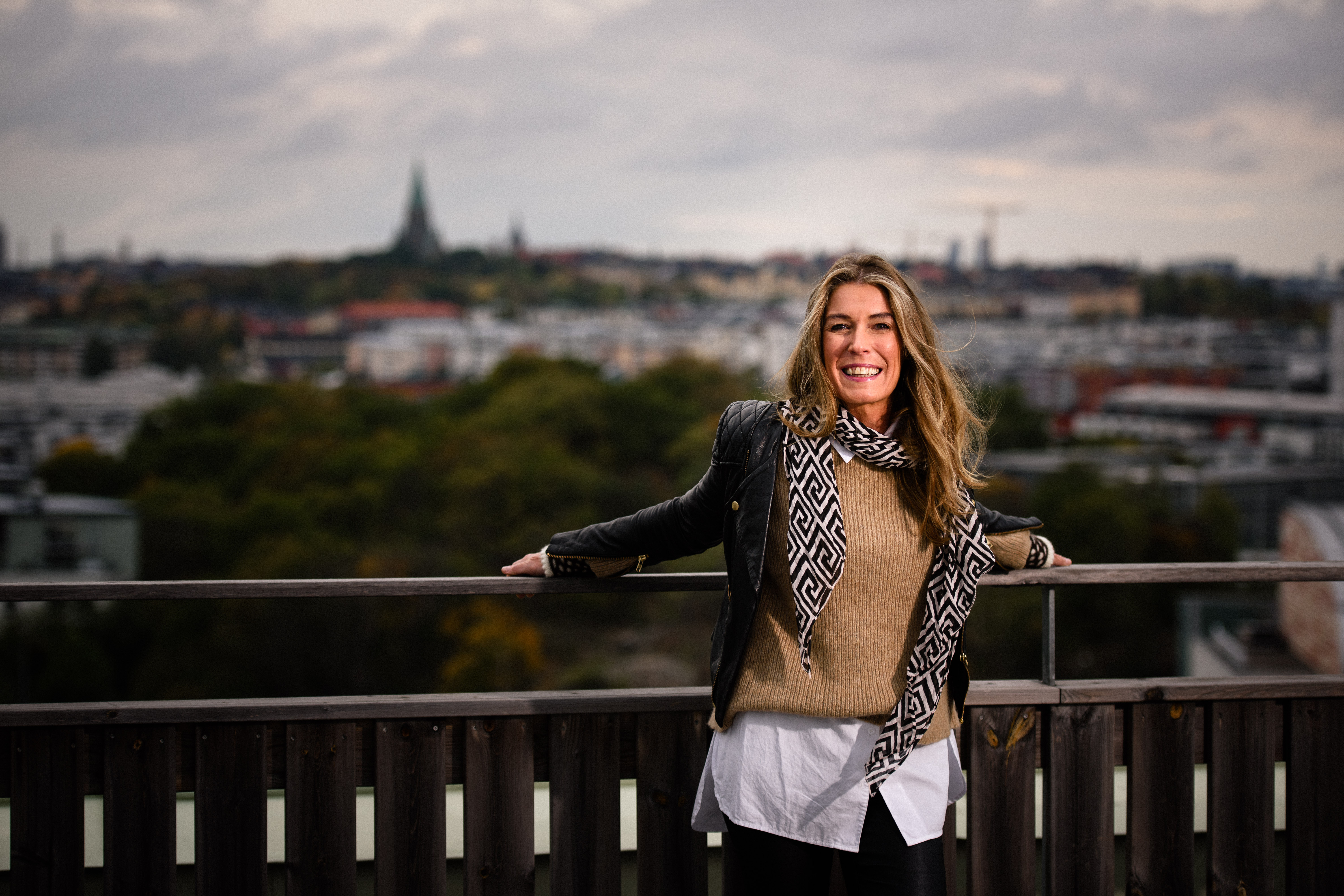 Kvinna med långt hår ler mot kameran. 